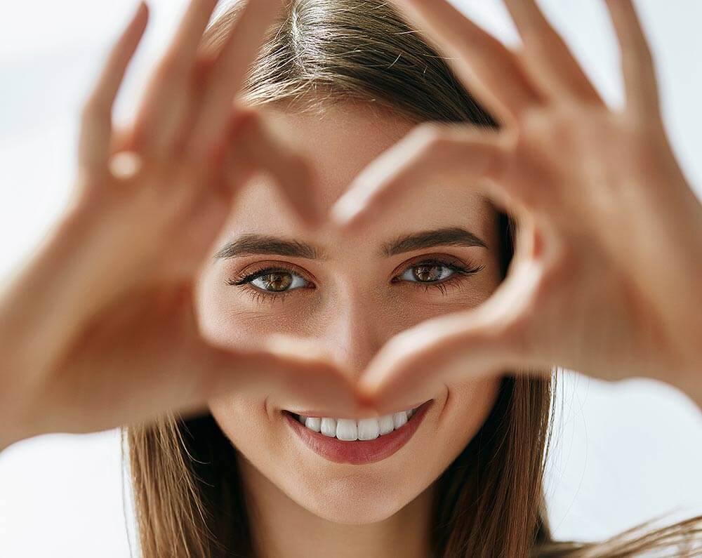 Woman Making a Heart Over Her Face